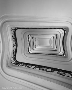 Black and white picture of Hotel Plaza Athénée in Paris featuring the beautiful staircase of the hotel.